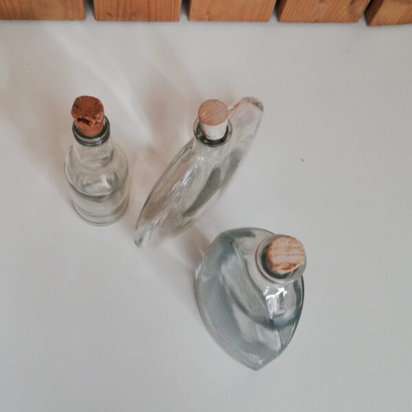 Set van drie glazen flessen in verschillende vormen